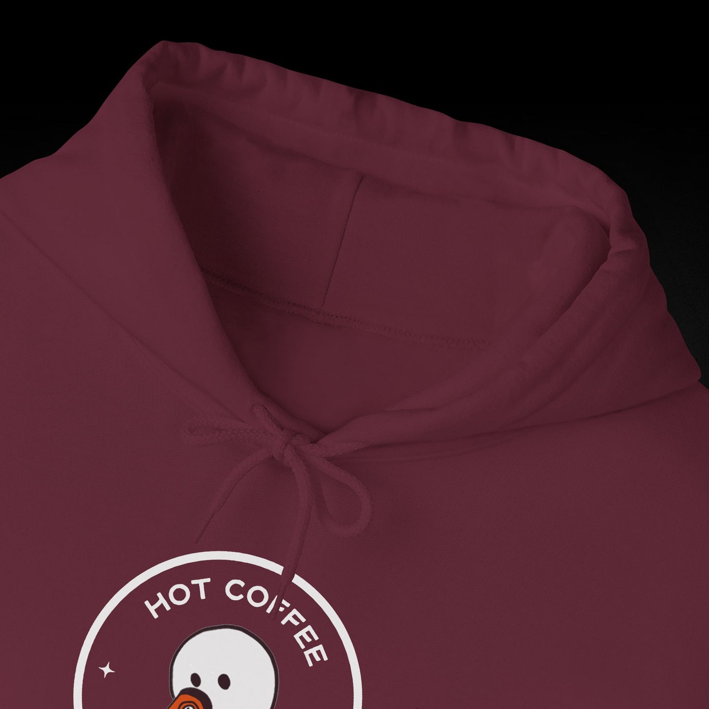 A close-up view of a burgundy hoodie with a white logo that says "HOT COFFEE" on it.